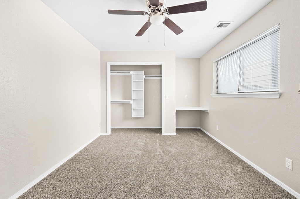 an empty room with a ceiling fan and a closet at Diamond Ridge Townhomes, Oklahoma