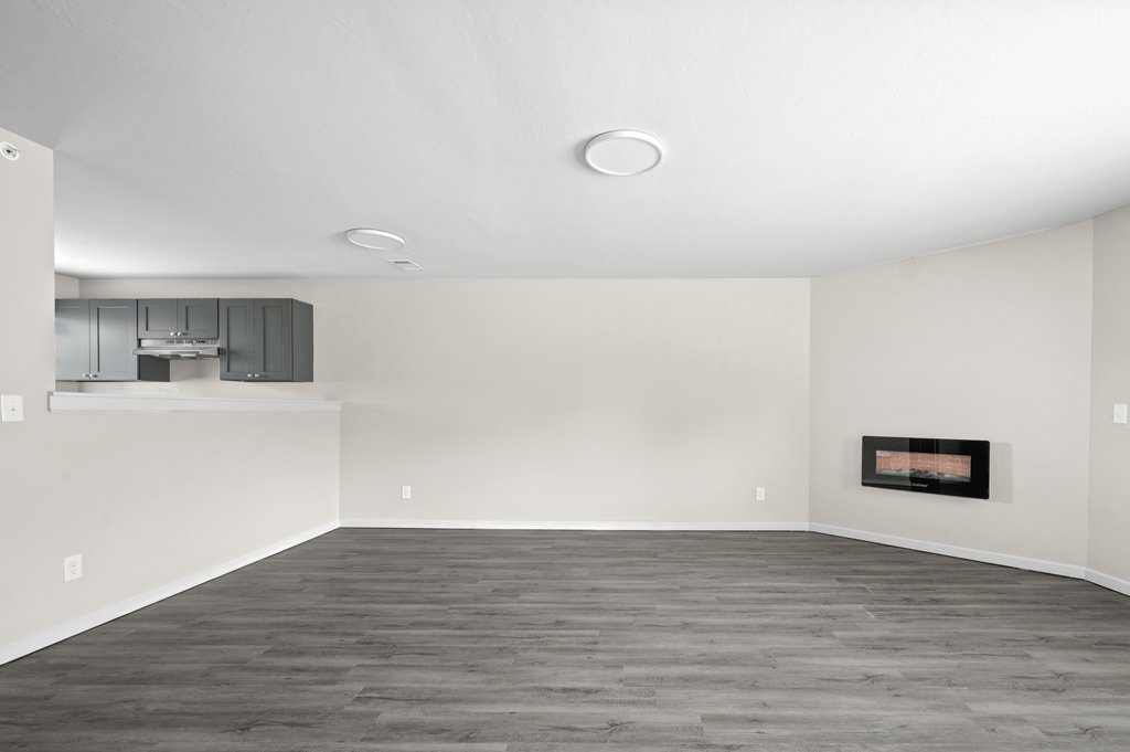 an empty living room with white walls and a fireplace at Diamond Ridge Townhomes, Oklahoma ,73114