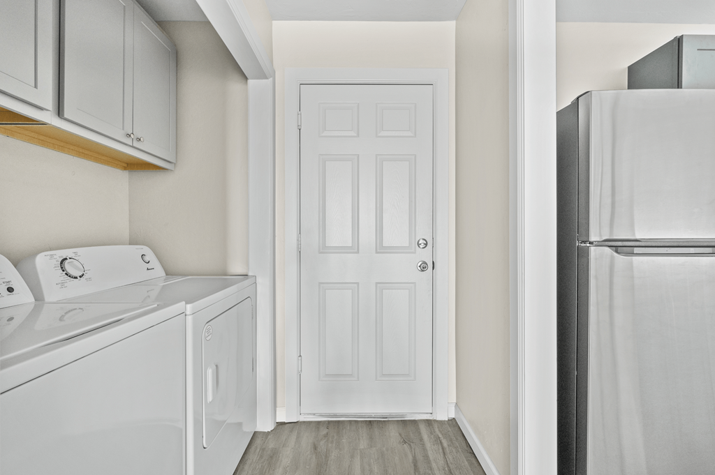 a white laundry room with a white refrigerator and a white door at Diamond Ridge Townhomes, Oklahoma City, OK 73114