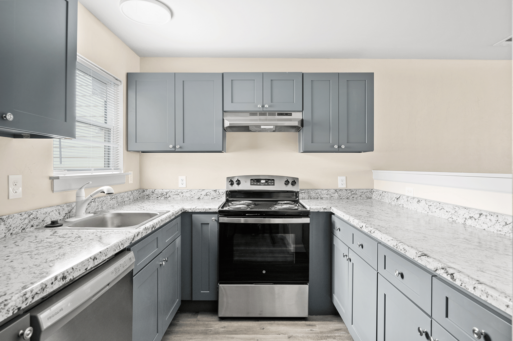 a kitchen with gray cabinets and white counter tops and a stove and sink at Diamond Ridge Townhomes, Oklahoma City Oklahoma