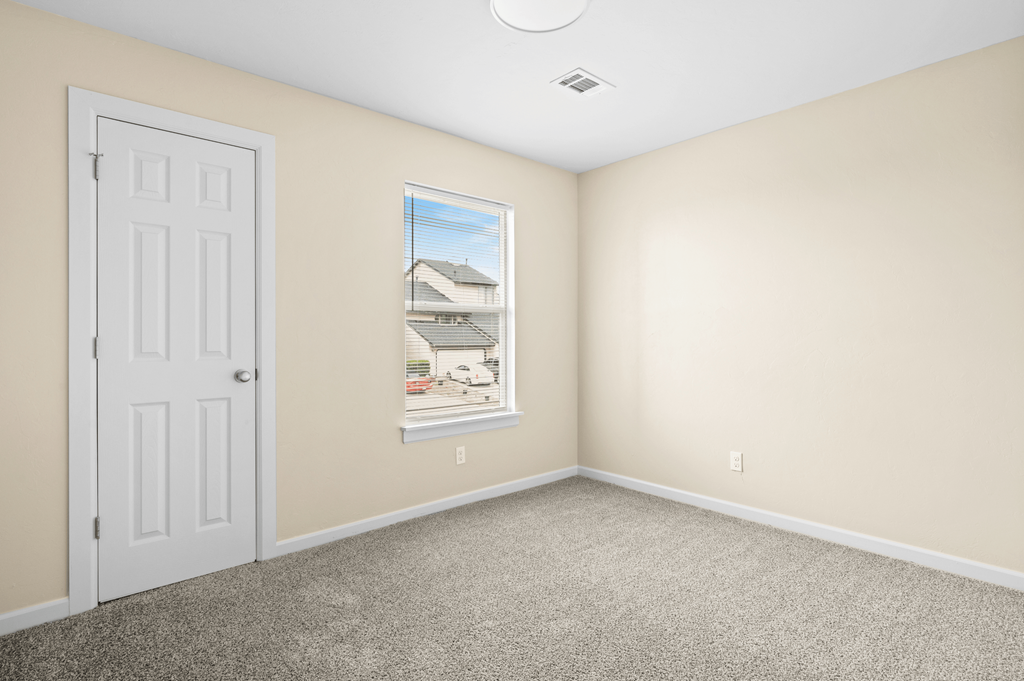 an empty room with a white door and a window at Diamond Ridge Townhomes, Oklahoma City, 73114