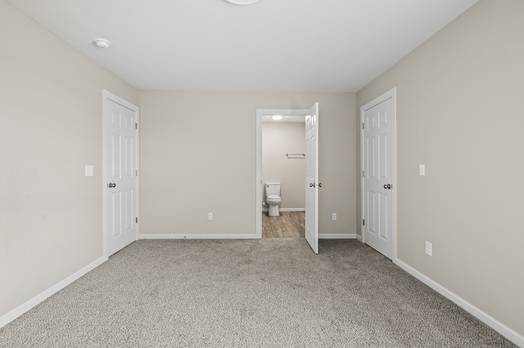 an empty room with two doors to a bathroom and a toilet at Diamond Ridge Townhomes, Oklahoma City Oklahoma
