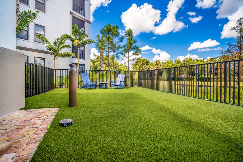 a yard with a ball and chairs in front of a fence at Magnolia Square, Naples, Florida