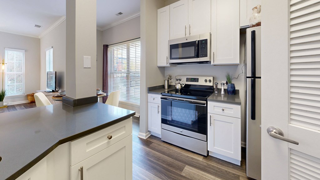 a kitchen with white cabinets and a stove and a microwave at Dwell at Naperville, Naperville, 60563