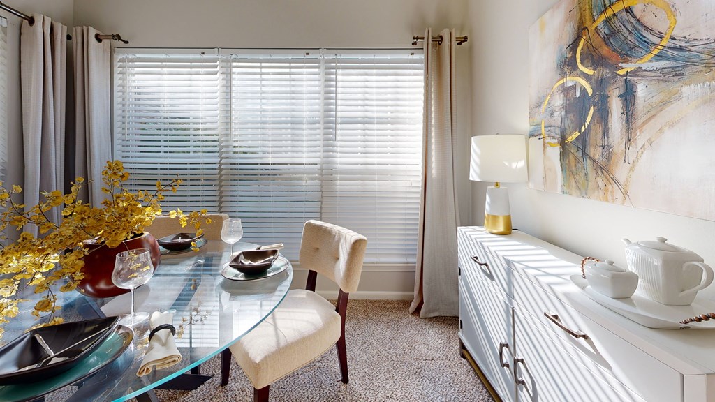 a dining room with a glass table and chairs and a large painting at Dwell at Naperville, Naperville, IL