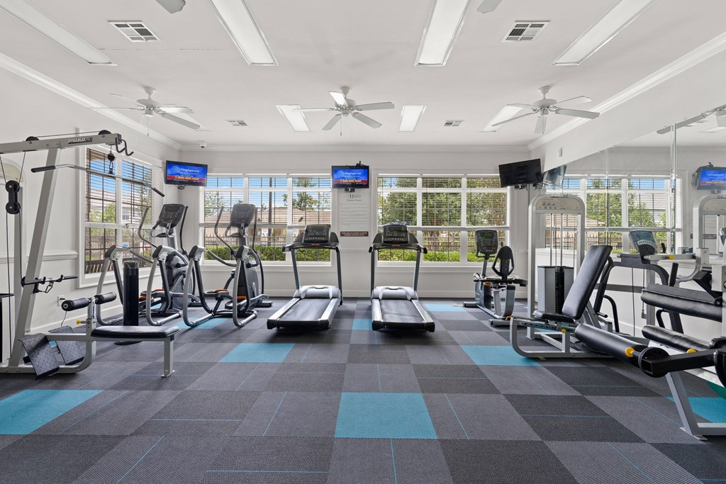 a large fitness room with treadmills and other exercise equipment