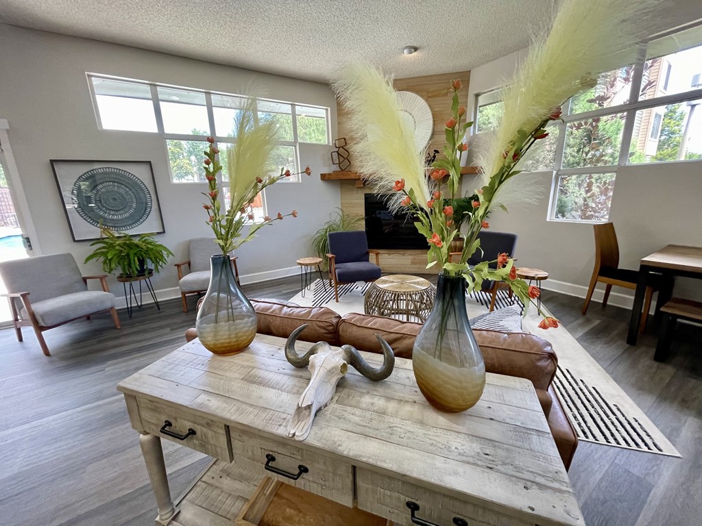 a living room with a large wooden table with vases on top of it