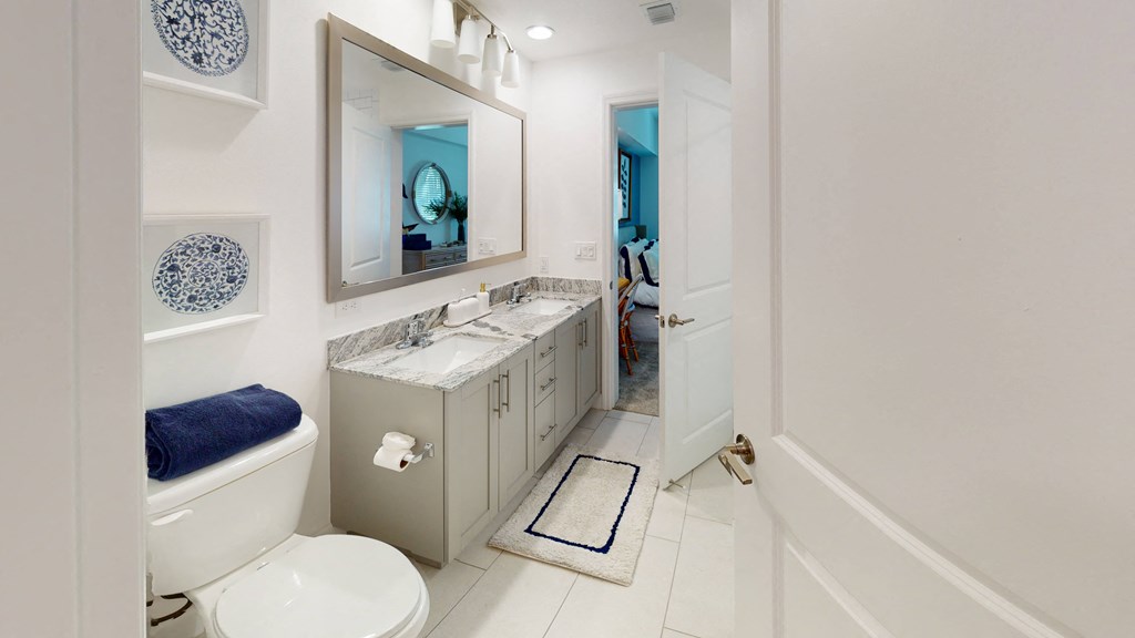 a bathroom with a toilet sink and mirror at The Lotus at Village Walk, Fort Myers, 33966