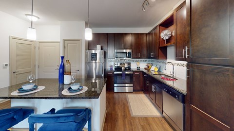 A modern kitchen with dark wood cabinets and a marble countertop.
