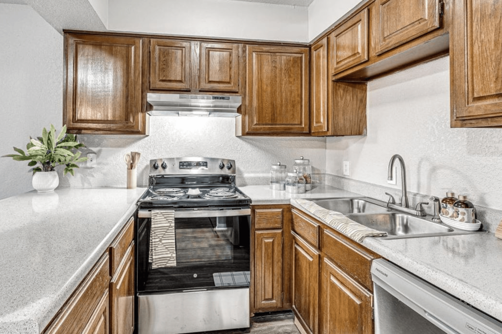 a kitchen with wooden cabinets and a stove and a sink