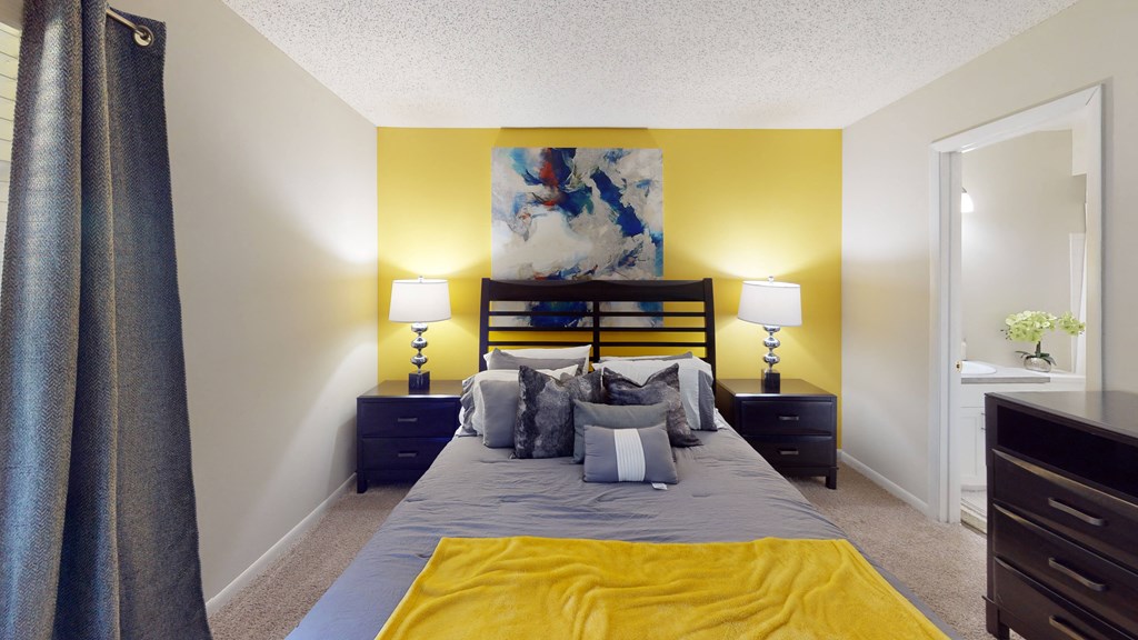 a bedroom with a bed and two night stands with lamps at Laurel Oaks Apartments, Tampa, Florida
