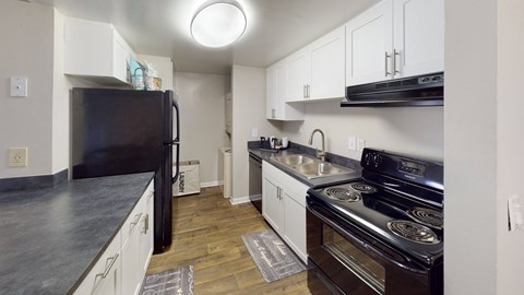 a kitchen with white cabinets and black appliances and a black refrigerator