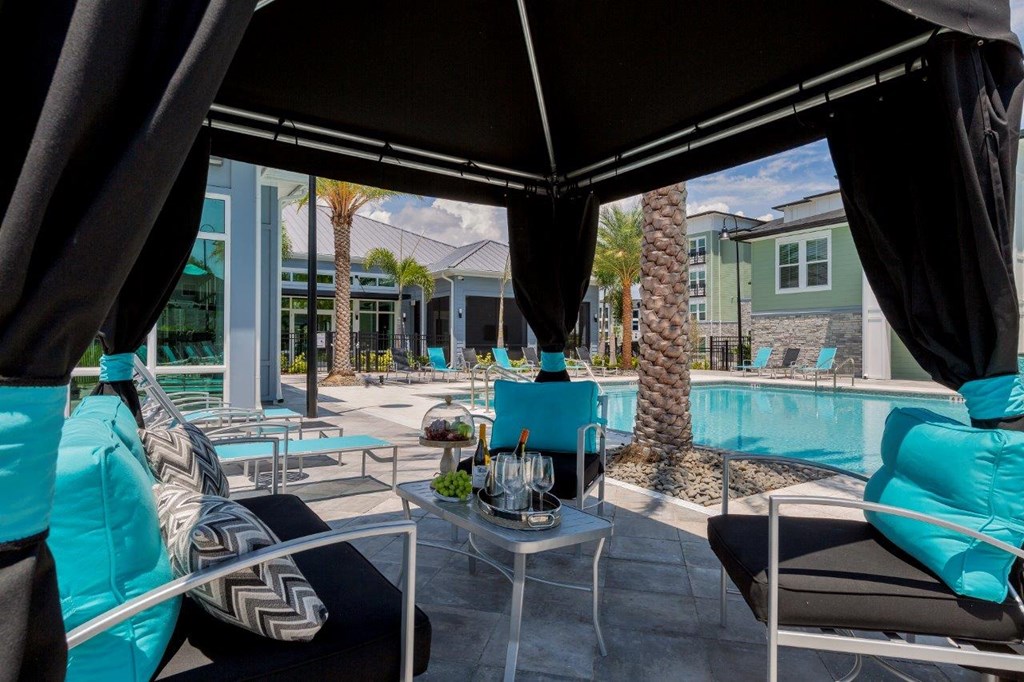 patio furniture around a swimming pool at the estates apartments