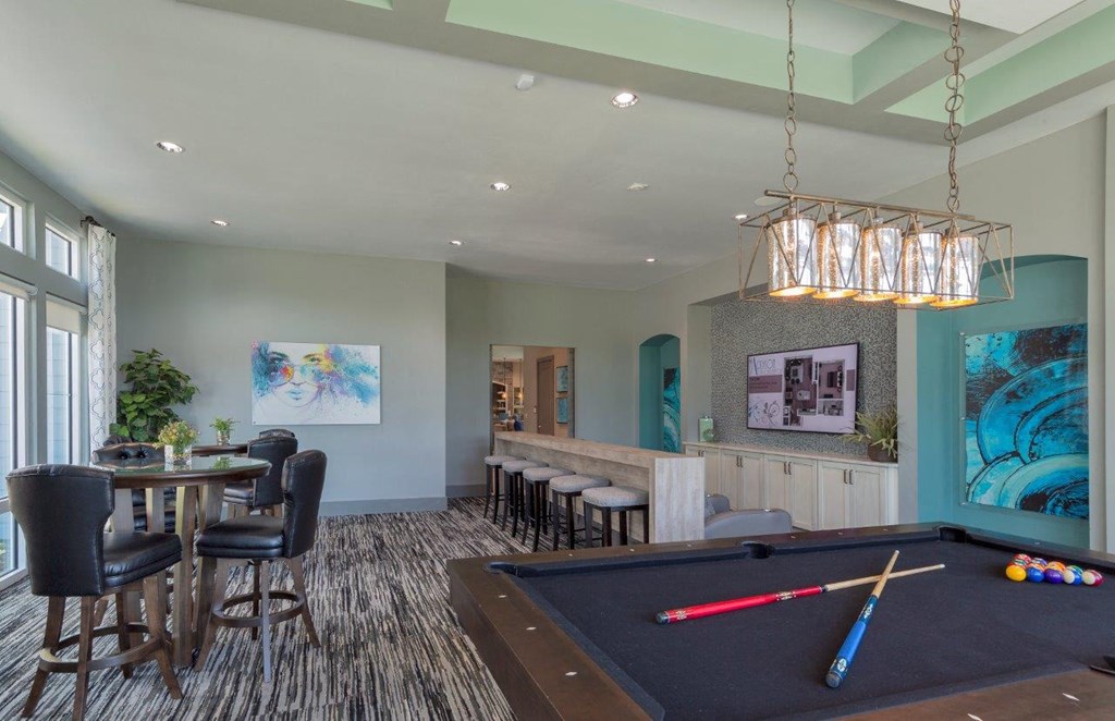 a game room with a pool table and a bar