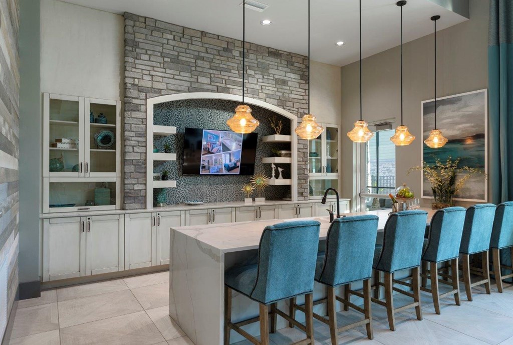 a kitchen with a bar and blue chairs