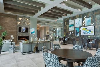 A modern living room with a fireplace and a TV at The Addison on Long Bayou Apartments, Seminole, FL, 33772