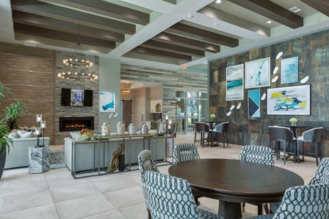 a dining room with a table and chairs and a fireplace a dining room with a table and chairs and a fireplace at The Addison on Long Bayou Apartments, Seminole, Florida