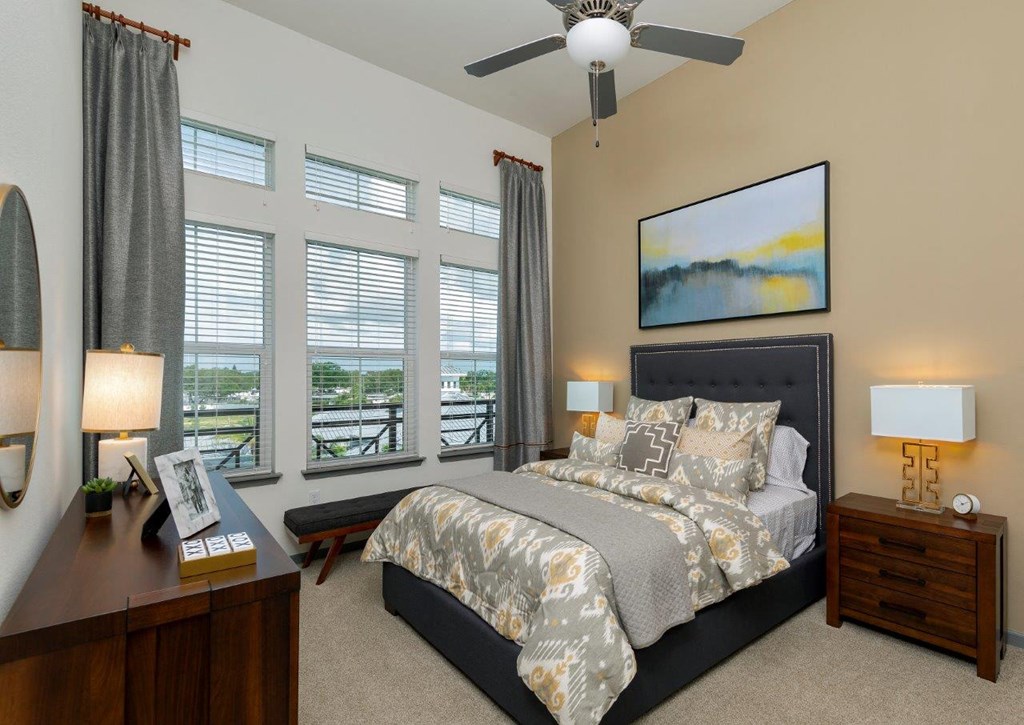 a bedroom with a large bed and a ceiling fan