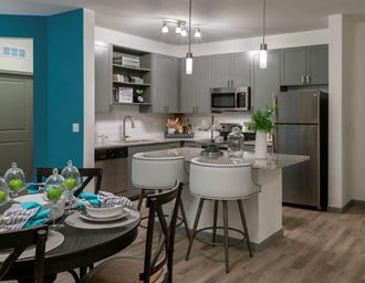 a kitchen with stainless steel appliances and a bar with stools
