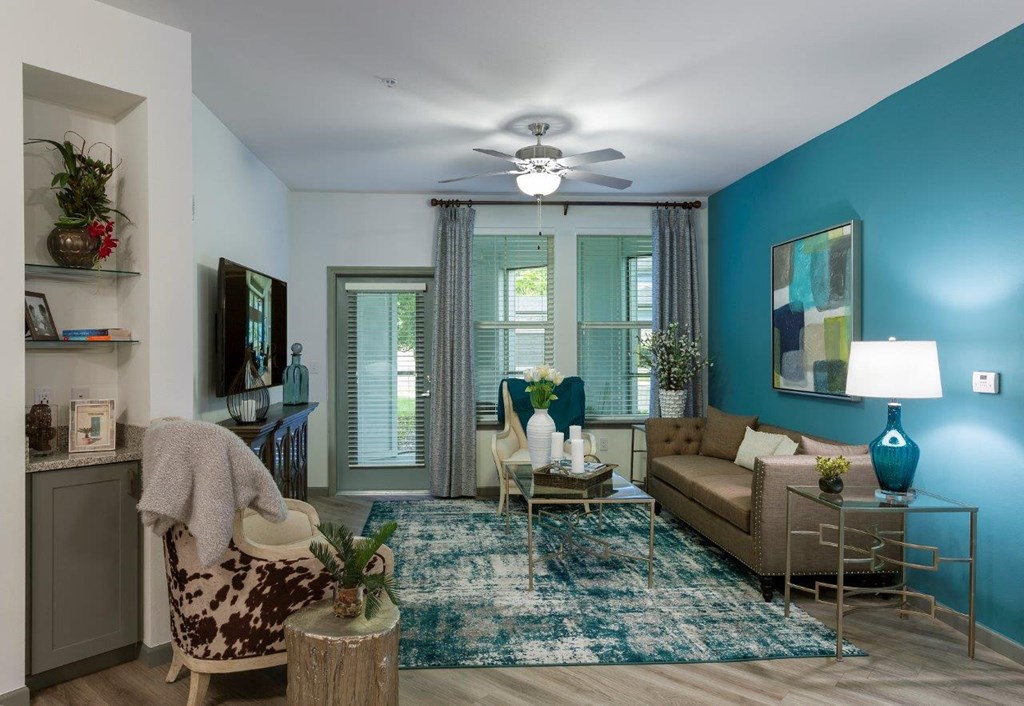 a living room with blue walls and a ceiling fan