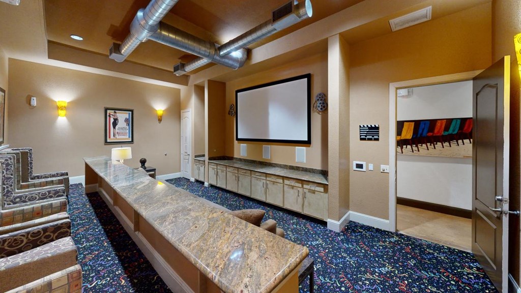 a large room with a long counter and a projector screen on the wall at The Millennium Towne Center Apartments, Baton Rouge, 70806