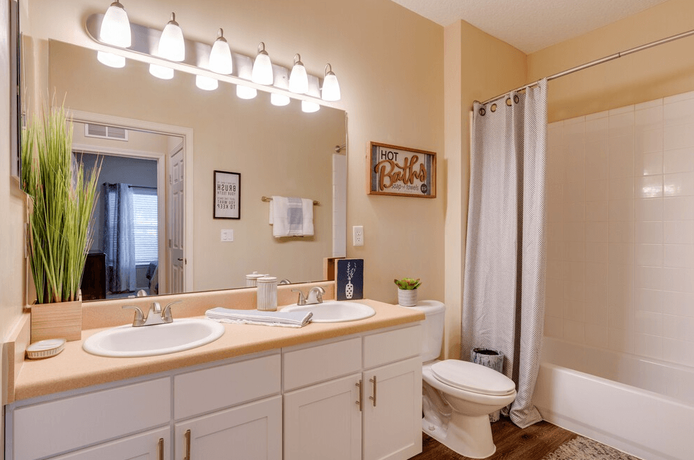 a bathroom with a toilet sink and shower at Magnolia Village Apartments, Florida