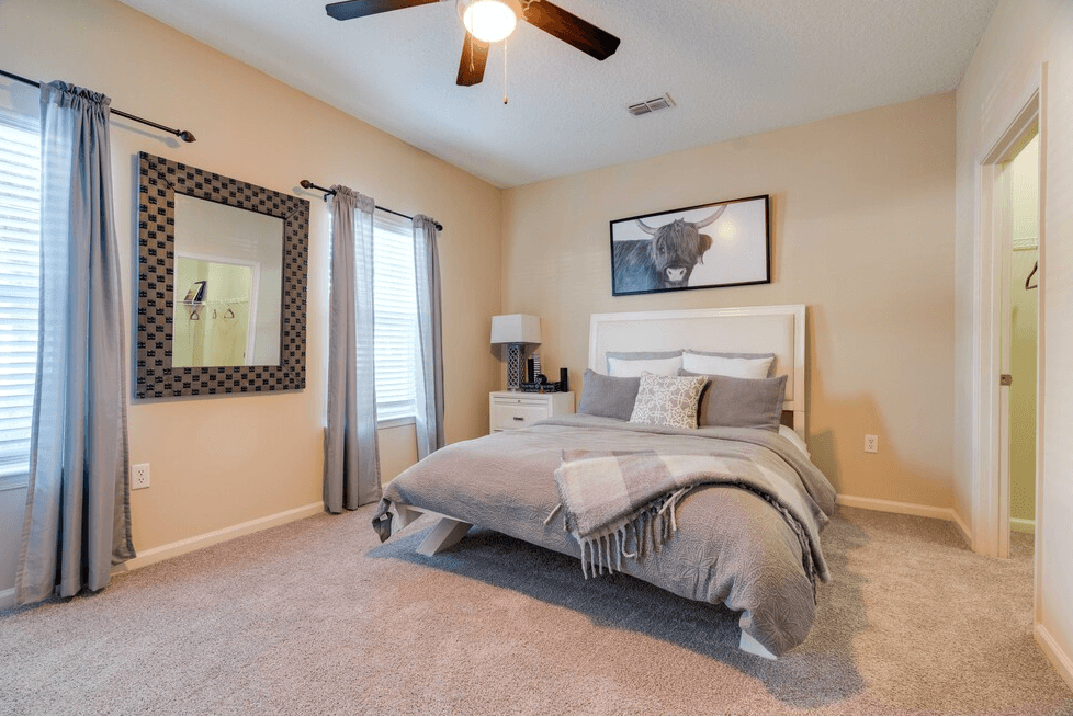a bedroom with a bed and a ceiling fan at Magnolia Village Apartments, Jacksonville, FL