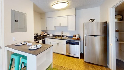 A kitchen with white cabinets and a stainless steel refrigerator.