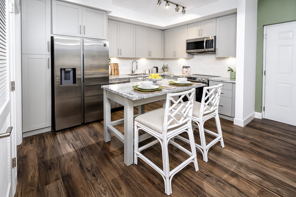 a kitchen with white cabinets and stainless steel appliances at The Lotus at Village Walk, Fort Myers, FL