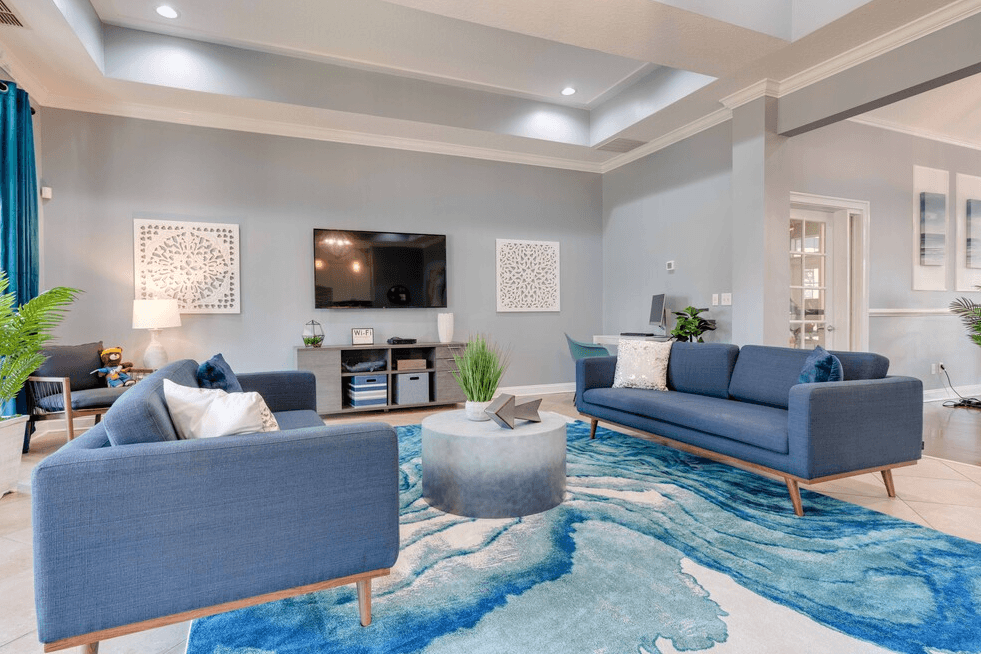 clubhouse with blue couches and a blue rug at Magnolia Village Apartments, Jacksonville, 32207