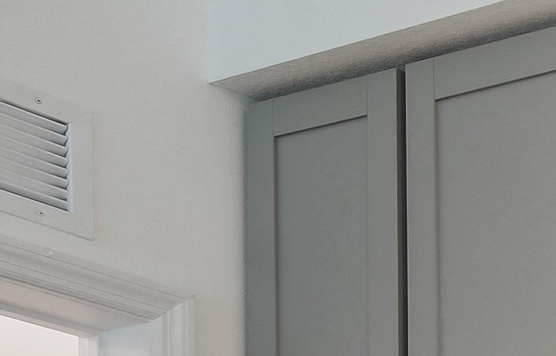 a kitchen with white cabinets and marble countertops - Photo Gallery
