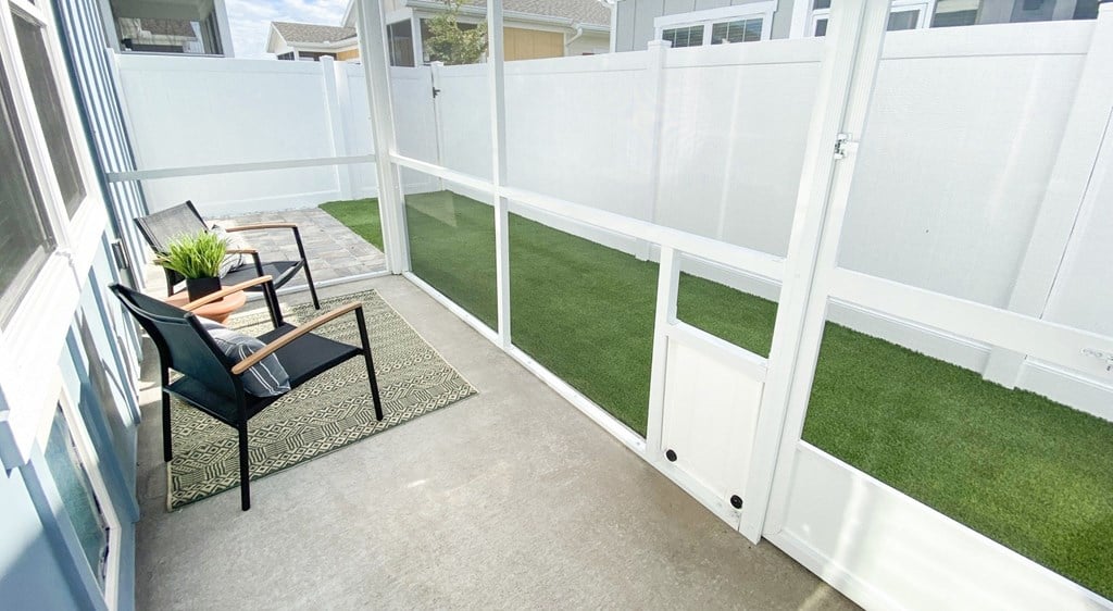 A small balcony with a chair and table.