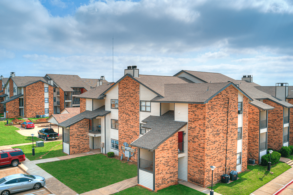 an aerial view of an apartment complex with cars parked outside