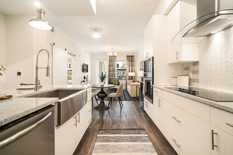 a large kitchen with white cabinets and stainless steel appliances