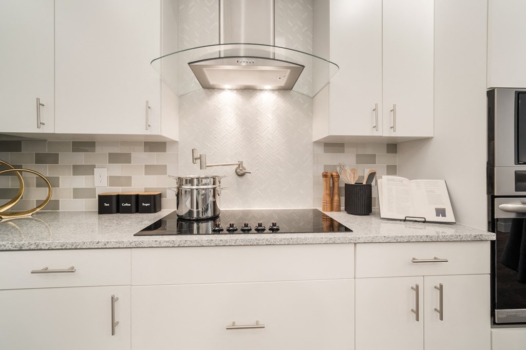a kitchen with white cabinets and a quartz countertop at Magnolia Square, Naples, 34109