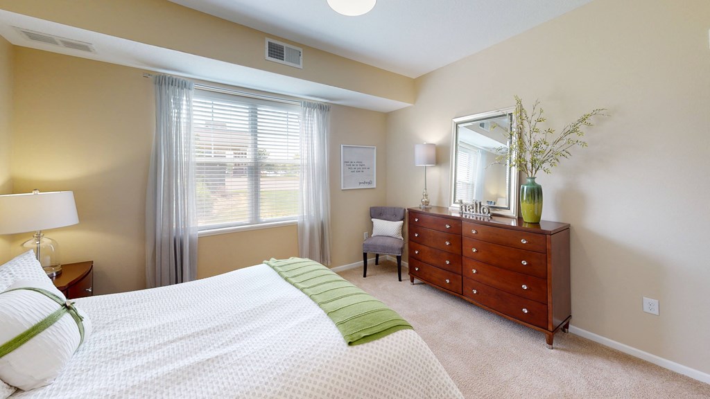 a bedroom with a large window and a dresser with a mirror at Skye at Arbor Lakes, Maple Grove, 55369