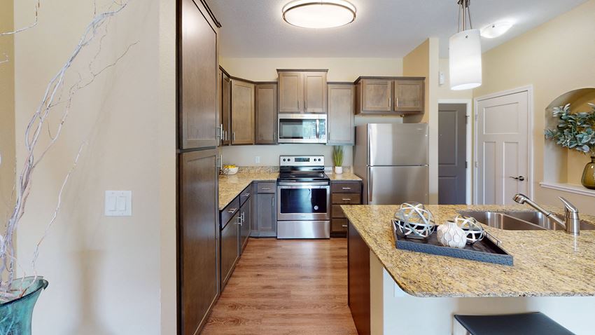 a kitchen with wooden cabinets and stainless steel appliances - Photo Gallery