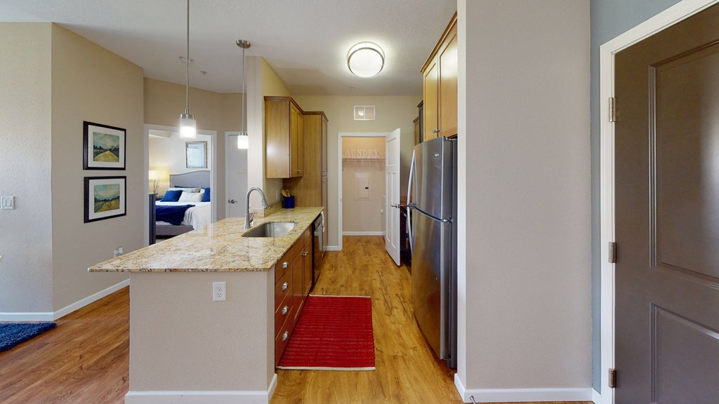 a kitchen with stainless steel appliances and a granite counter top at Skye at Arbor Lakes, Maple Grove, Minnesota