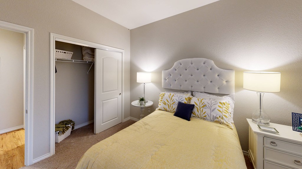 a bedroom with a bed and a closet with a door open