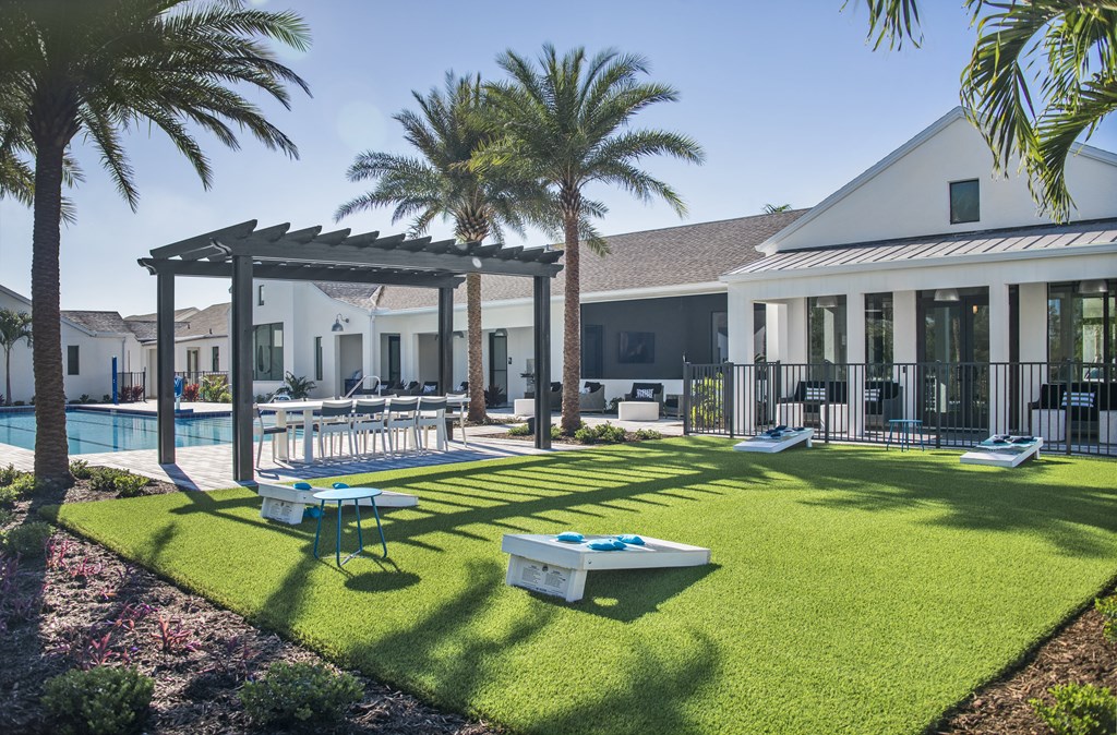 a backyard with a swimming pool and pergola at Odyssey, Fort Myers