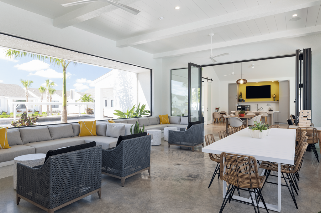 Open concept resident space with a white dining table and rattan chairs at Odyssey, Florida