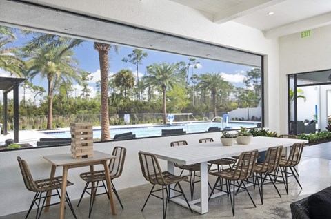 a large white table and chairs sit in front of a large window with a view of a at Odyssey, Fort Myers, FL, 33905