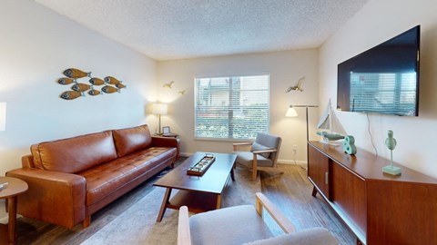 A living room with a brown leather couch and a wooden coffee table.