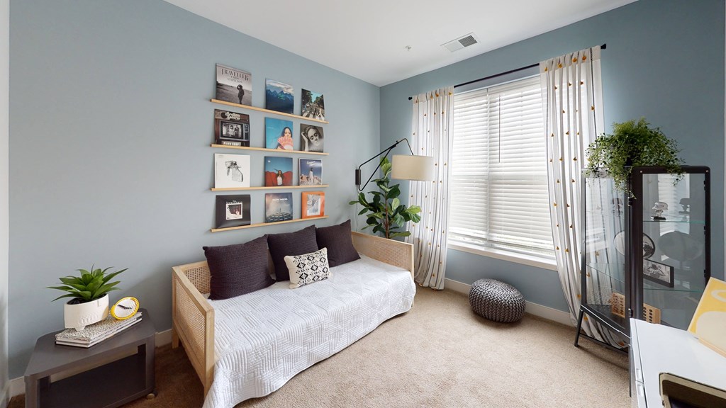 a bedroom with blue walls and a bed with a white comforter