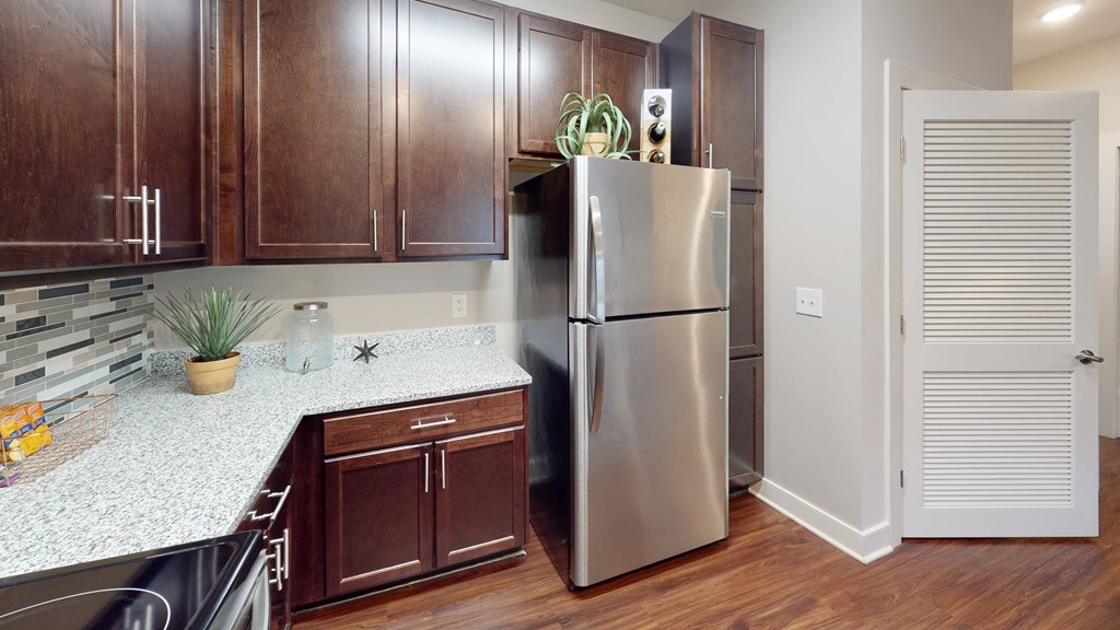 a kitchen with dark wood cabinets and white countertops