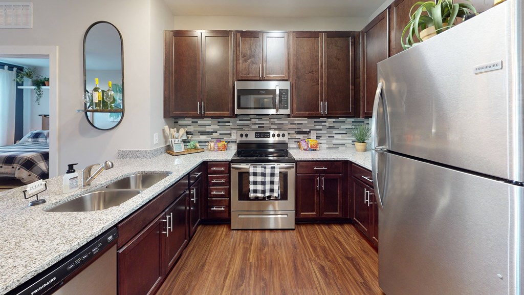 a kitchen with dark wood cabinets and stainless steel appliances