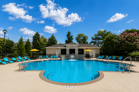 A large swimming pool with a waterfall feature in the middle.