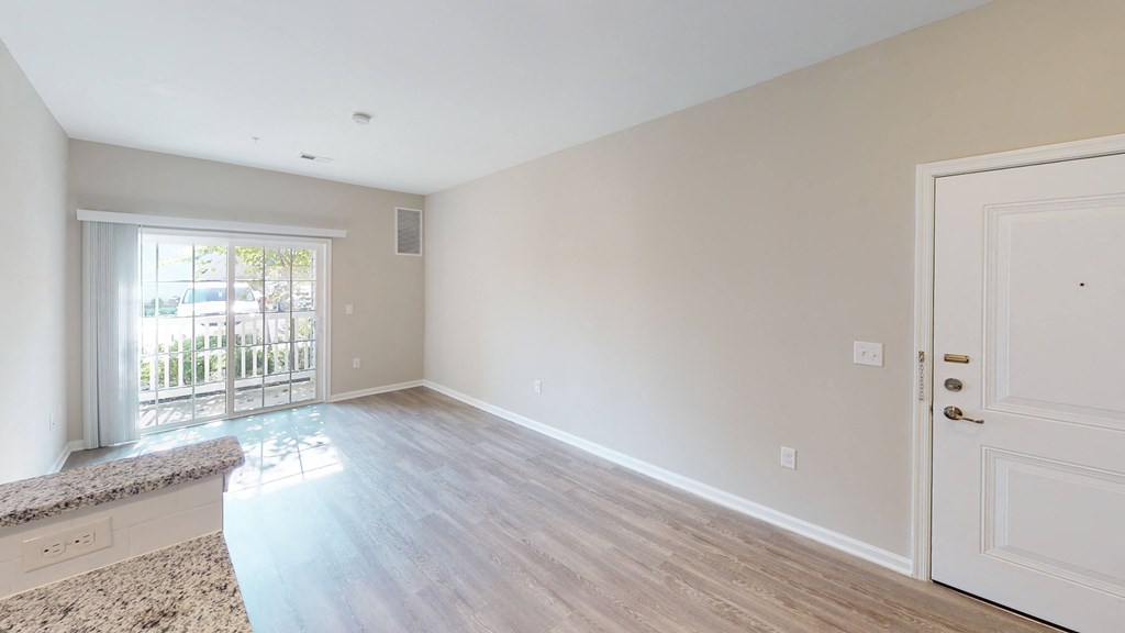 a bedroom with hardwood flooring and a door leading to a balcony at The Landing Apartment , New Jersey, 07730