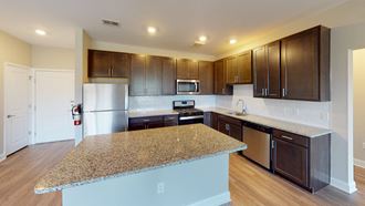 a kitchen with dark wood cabinets and an island with granite countertops