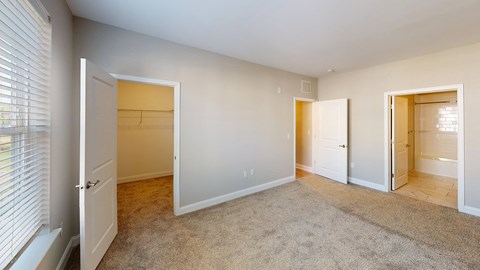 a bedroom with a closet and a door to a bathroom